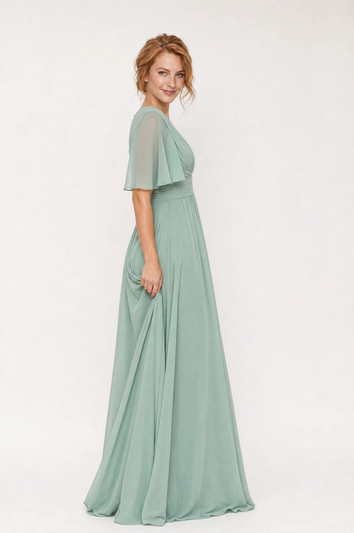 Robe demoiselle d'honneur mousseline vert sauge Rosalie vue de profil portée par Julie, taille empire drapée, jupe en mousseline fluide, longueur au sol