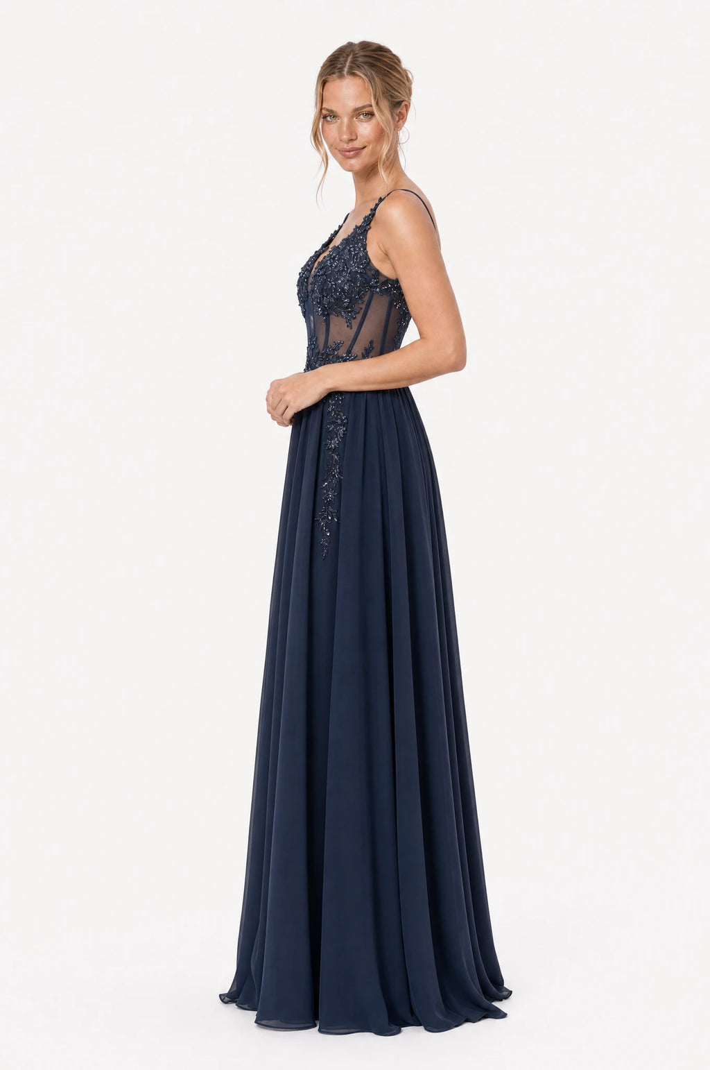 Robe de gala bleu marine Delphine vue de profil portée par Aude chignon bas, silhouette évasée en A, bustier structuré en dentelle perlée, jupe longue en mousseline fluide