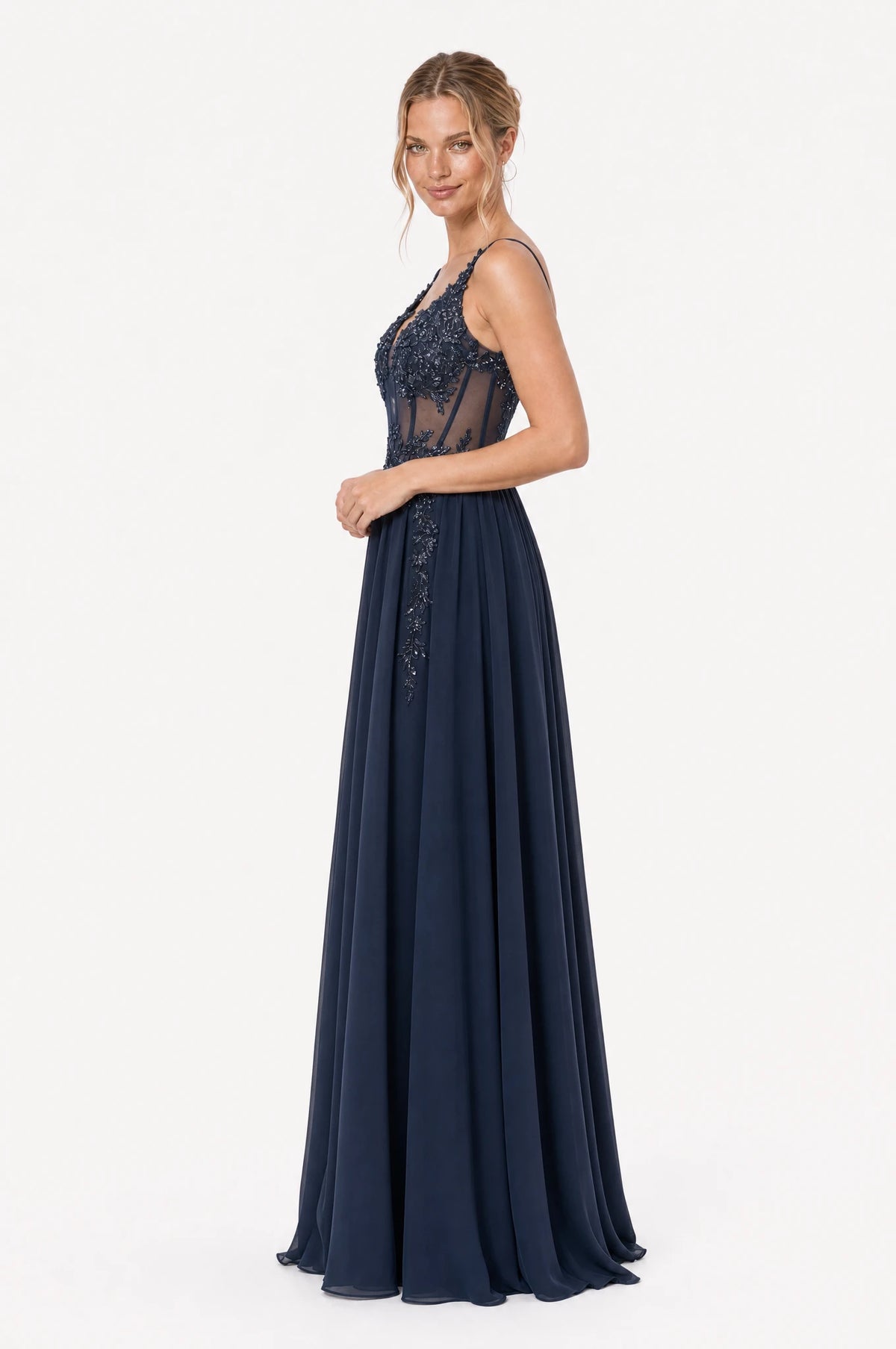 Robe de gala bleu marine Delphine vue de profil portée par Aude chignon bas, silhouette évasée en A, bustier structuré en dentelle perlée, jupe longue en mousseline fluide