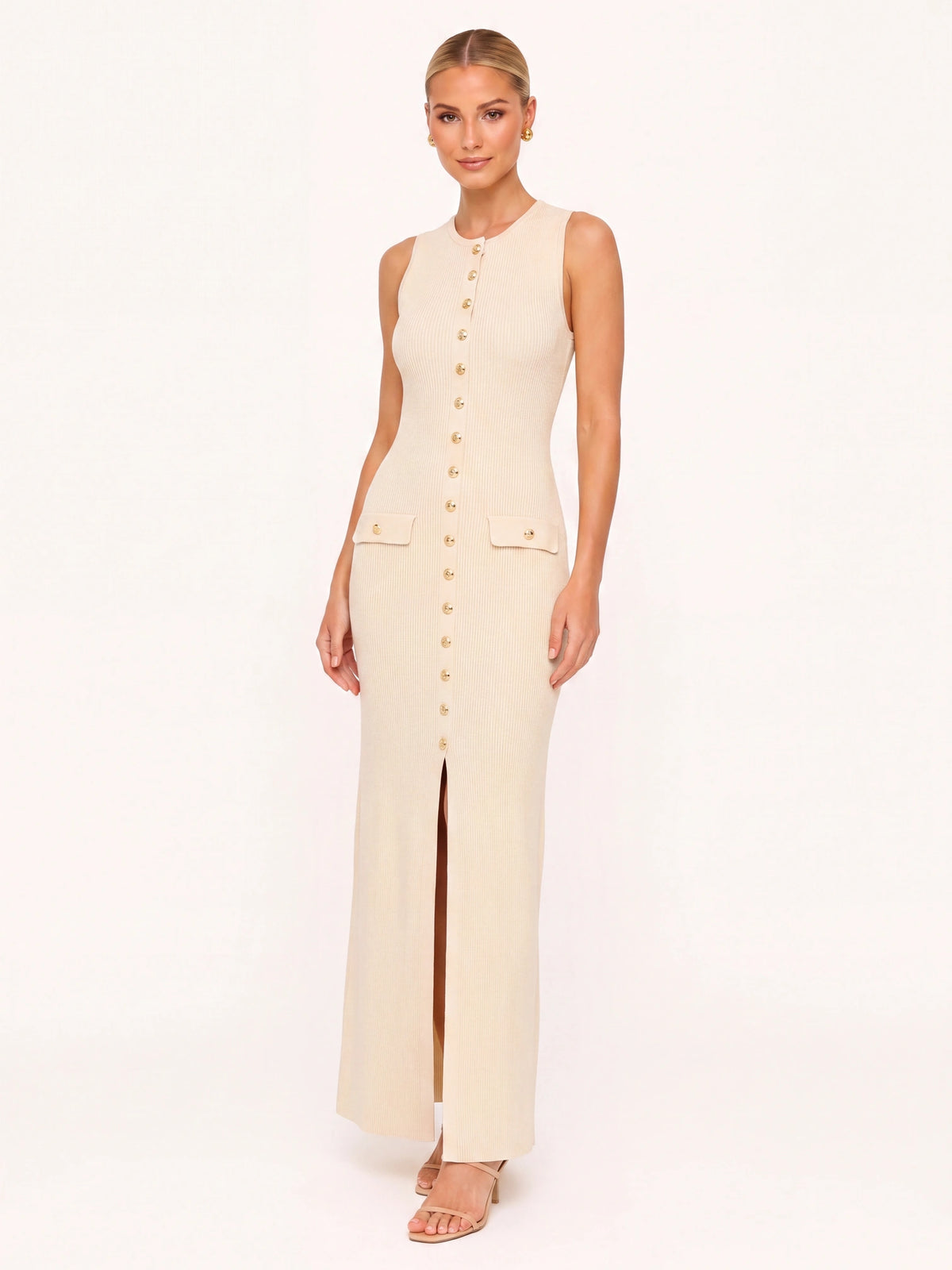 Robe longue en maille beige ivoire Lina portée de face par une mannequin blonde souriante, robe bien visible sur fond neutre clair, maille côtelée nette, boutons dorés et coupe ajustée.