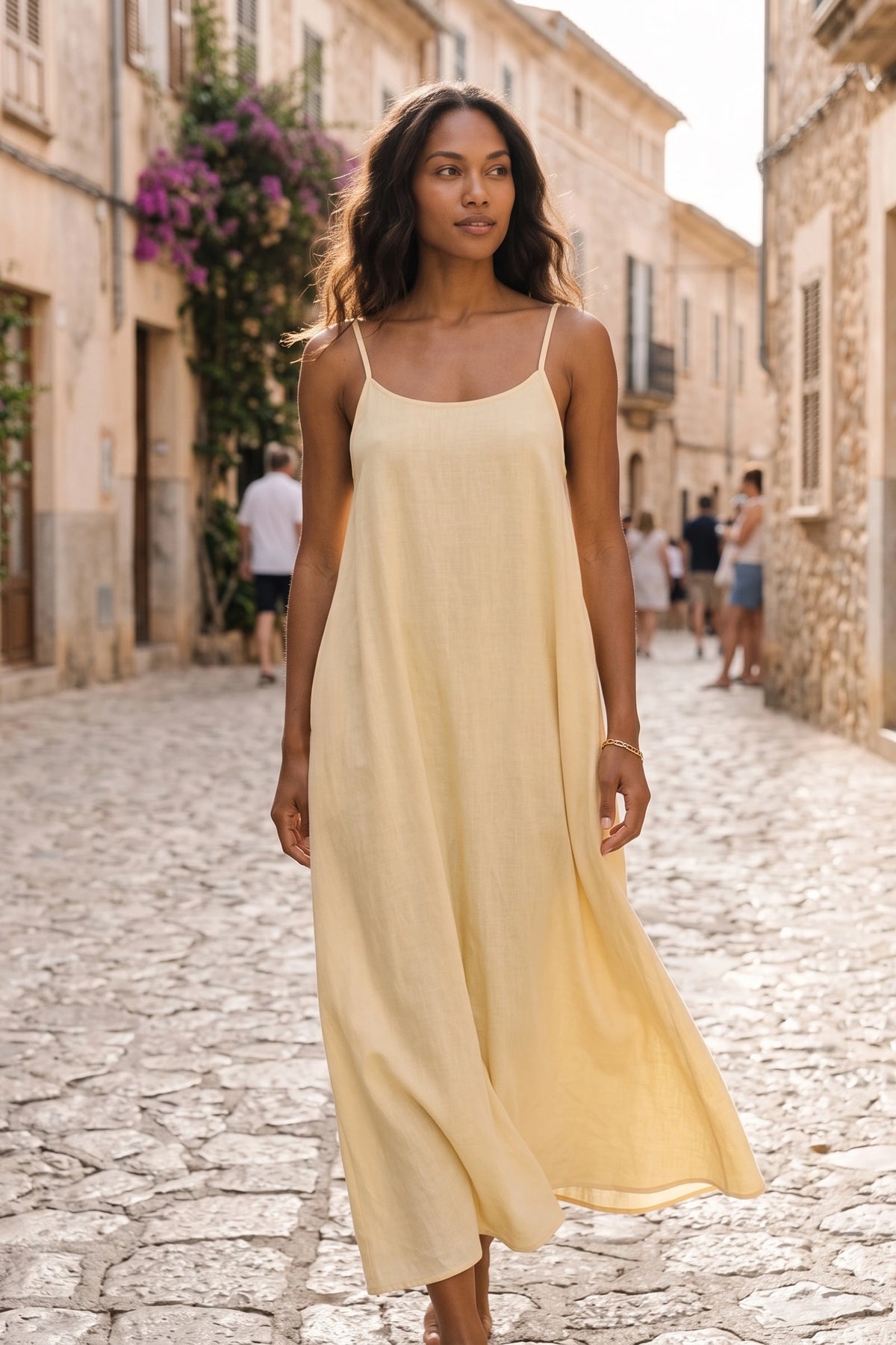 Robe longue casual dos nu Soline couleur Jaune en lifestyle naturel par mannequin métisse cheveux détachés, fines bretelles, dos ouvert arrondi avec petit détail bas du dos et coupe fluide