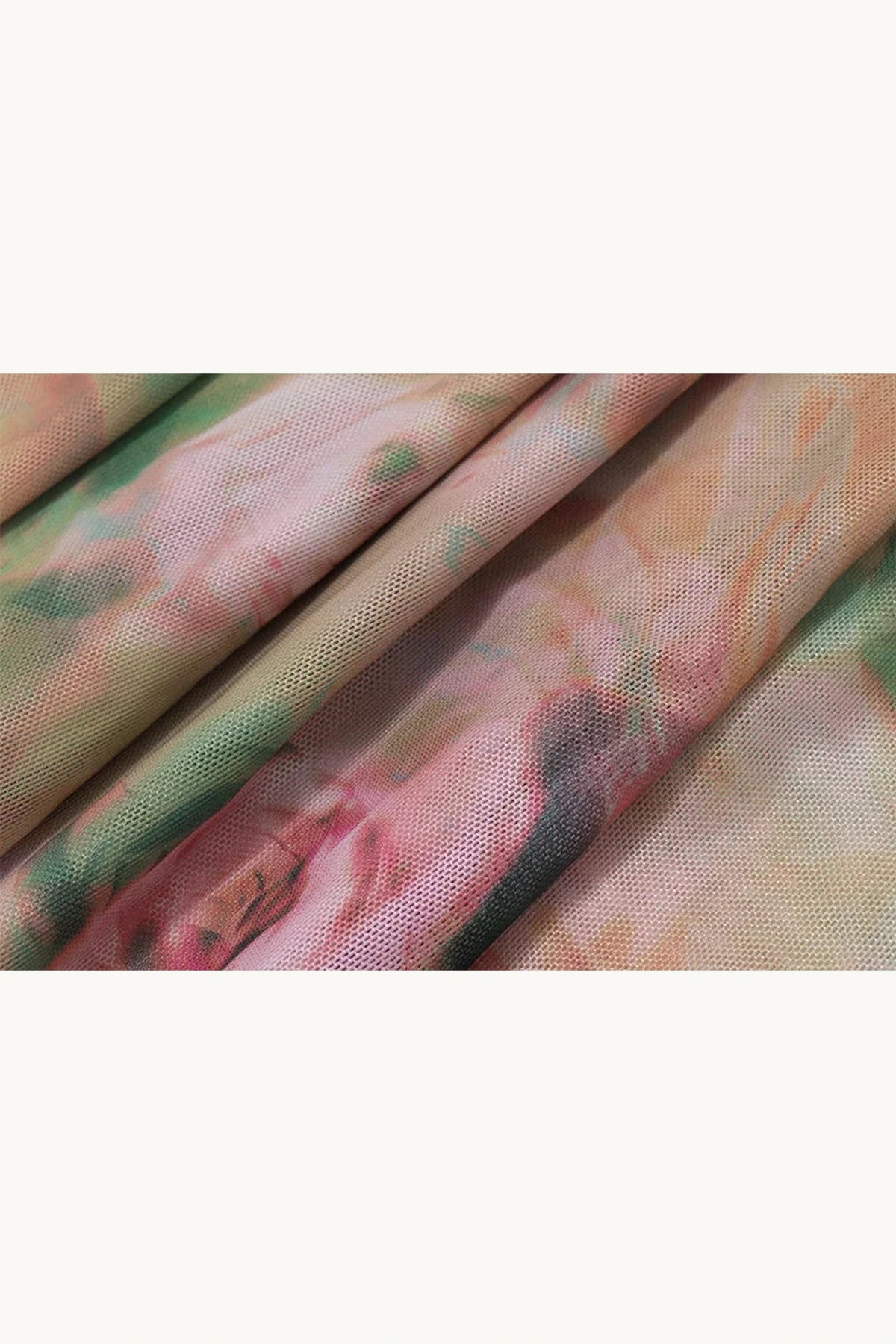 Aperçu du tissu en tulle drapé à l'imprimé floral aux tons pastel vert et rose. L'échantillon permet de se rendre compte de la fluidité et du beau dégradé de couleur de cette élégante robe longue fendue.