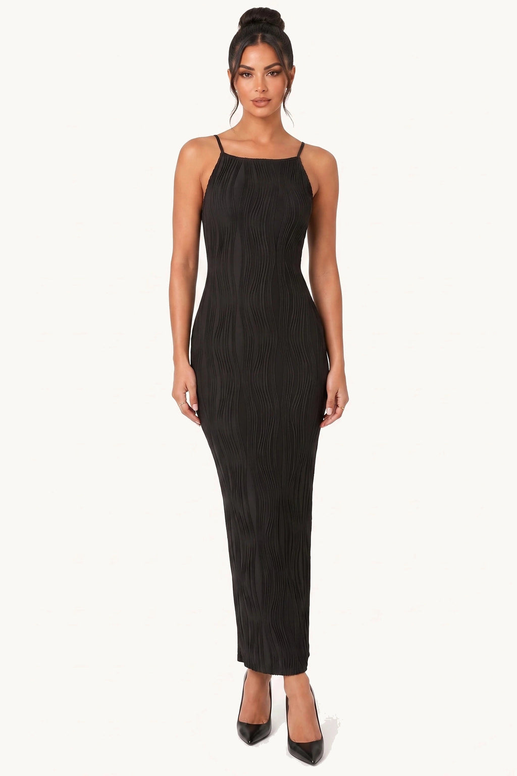 Robe moulante longue Maëlys noire portée de face par le mannequin Diane Camille sur fond neutre clair, fines bretelles, texture plissée ondulée et silhouette ajustée