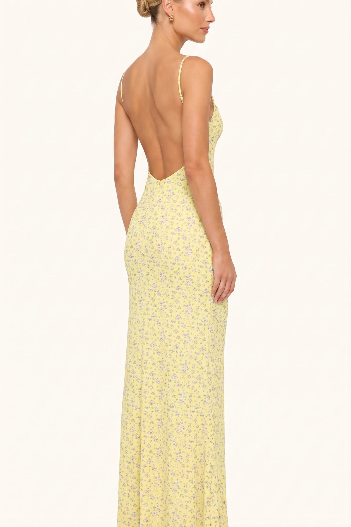 Robe moulante longue fleurie Livia jaune vue de dos sur Chloé, dos dégagé et fines bretelles sur fond neutre clair