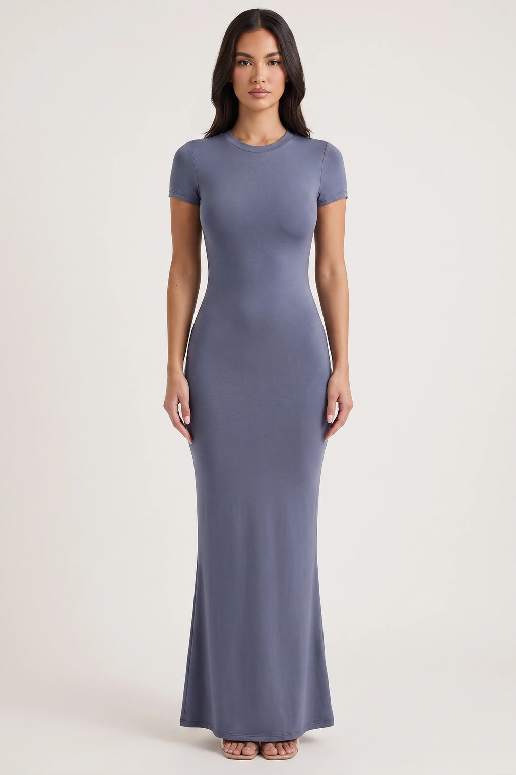 Robe moulante longue Mila bleu grisé portée de face par Camille sur fond neutre clair, manches courtes et ligne près du corps