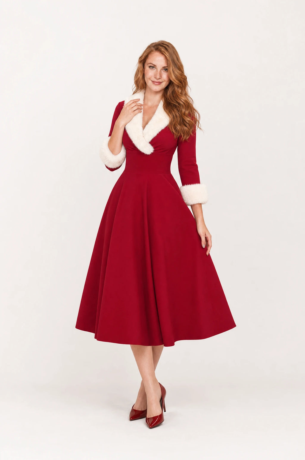 Robe de Noël rouge fausse fourrure Luna portée de face par Julie cheveux roux détachés, col fausse fourrure blanche en V, manches trois quarts à poignets fourrure, taille cintrée, jupe évasée en cercle, robe vintage de Noël chic