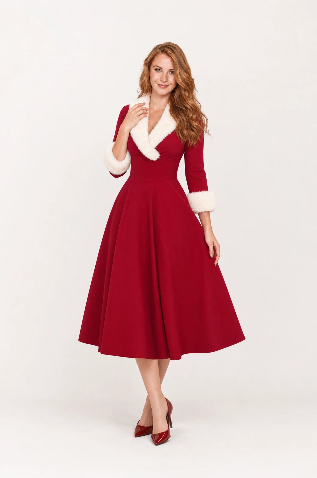 Robe de Noël rouge fausse fourrure Luna portée de face par Julie cheveux roux détachés, col fausse fourrure blanche en V, manches trois quarts à poignets fourrure, taille cintrée, jupe évasée en cercle, robe vintage de Noël chic