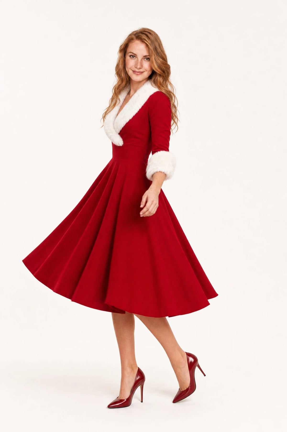 Robe de Noël rouge fausse fourrure Luna vue de profil portée par Julie, jupe évasée en cercle qui virevolte au mouvement, manches trois quarts à poignets fourrure, coupe vintage cintrée, robe hiver femme élégante