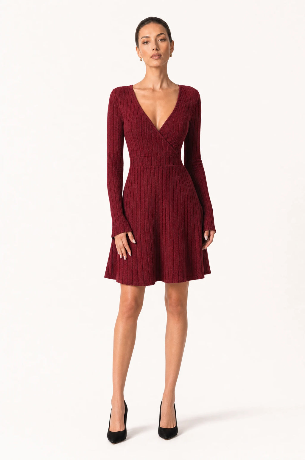 Robe pull rouge cache coeur en maille côtelée Victoire portée de face par Nath, décolleté croisé profond en V, taille marquée par une couture, manches longues légèrement évasées aux poignets, jupe courte évasée fit and flare, tenue chic idéale pour une soirée d'automne ou d'hiver