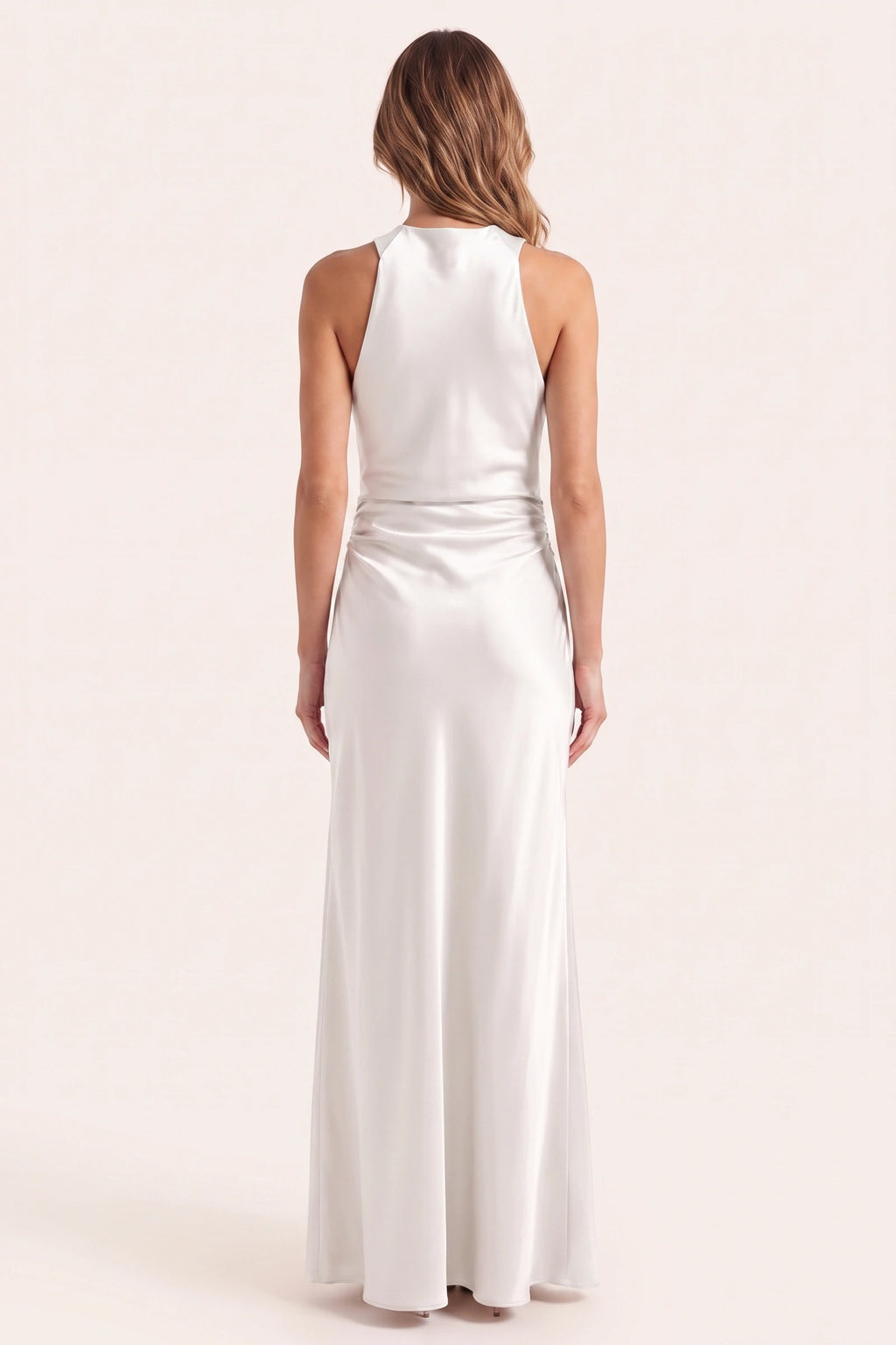 Robe de soirée satinée Élena blanche portée de dos sur fond neutre clair, nuque et col licou corrigés, tombé fluide pour cérémonie chic