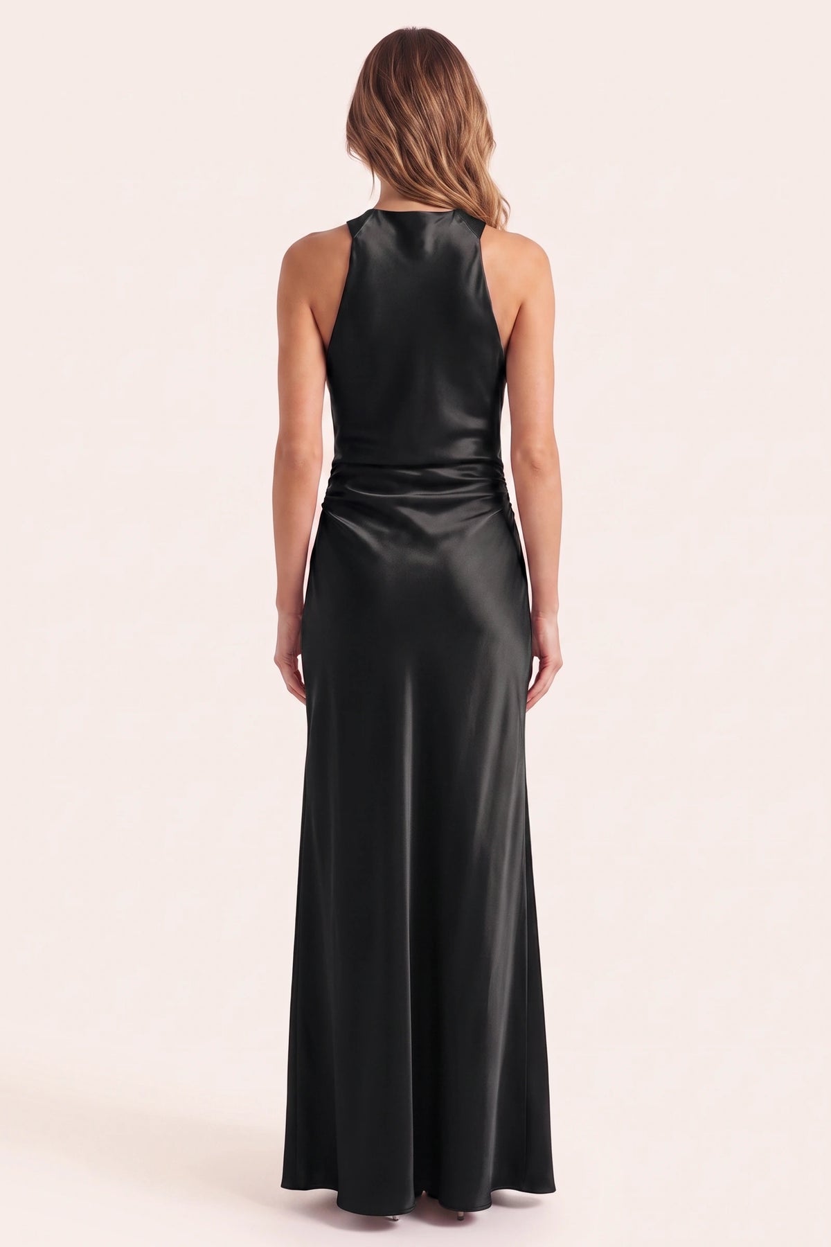 Robe de soirée satinée Élena noire portée de dos sur fond neutre clair, haut du dos conforme, col licou et silhouette longue élégante