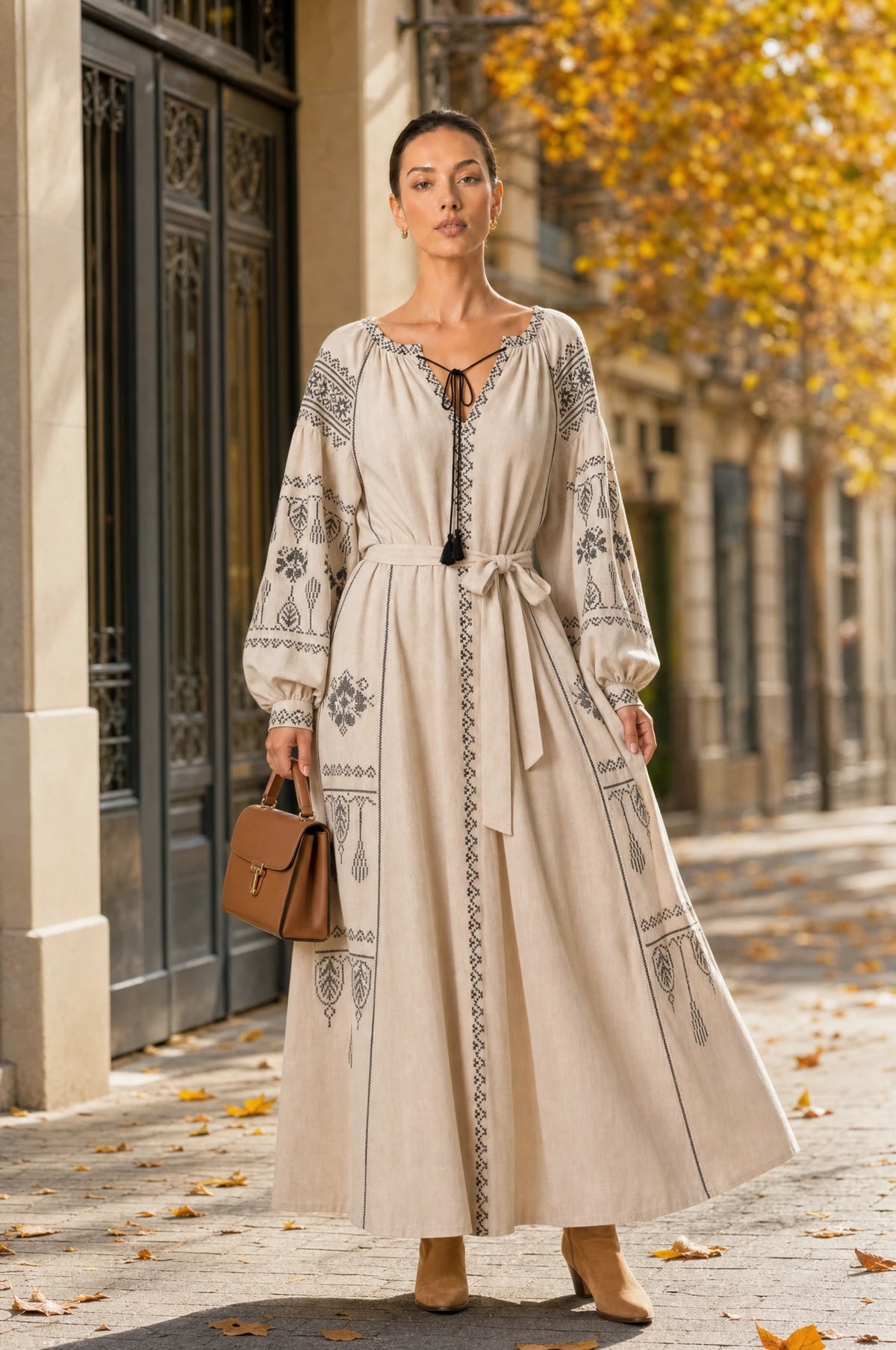 Robe vintage brodée beige Elsa portée par Nath dans une rue européenne chic en automne, feuilles dorées, ambiance élégante de journée d'automne