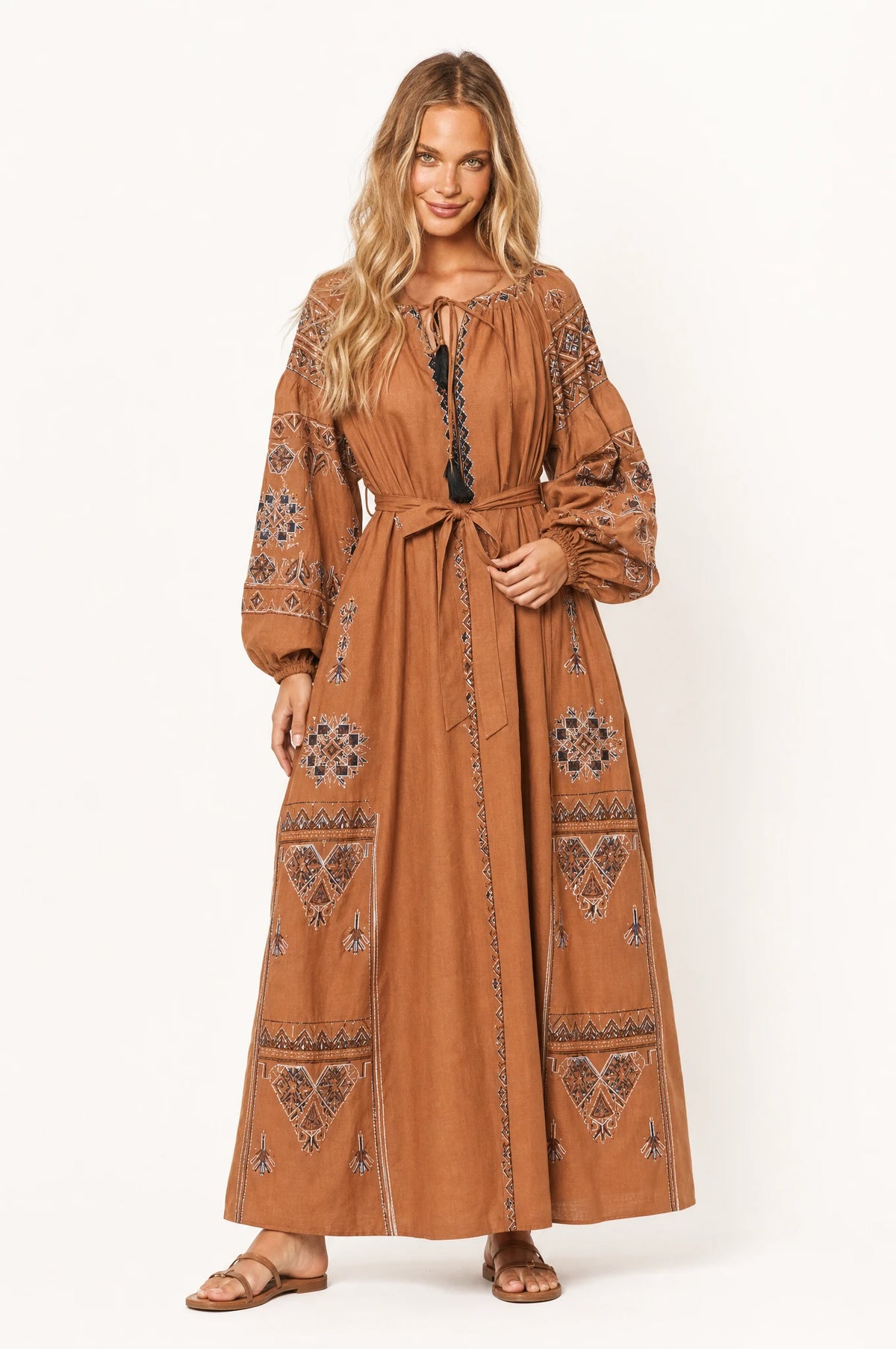 Robe vintage brodée marron Margot portée de face par Aude, décolleté rond fermé par un lacet noué, manches longues bouffantes resserrées au poignet, ceinture nouée à la taille, broderies ethniques sur les manches et la jupe, style folk chic