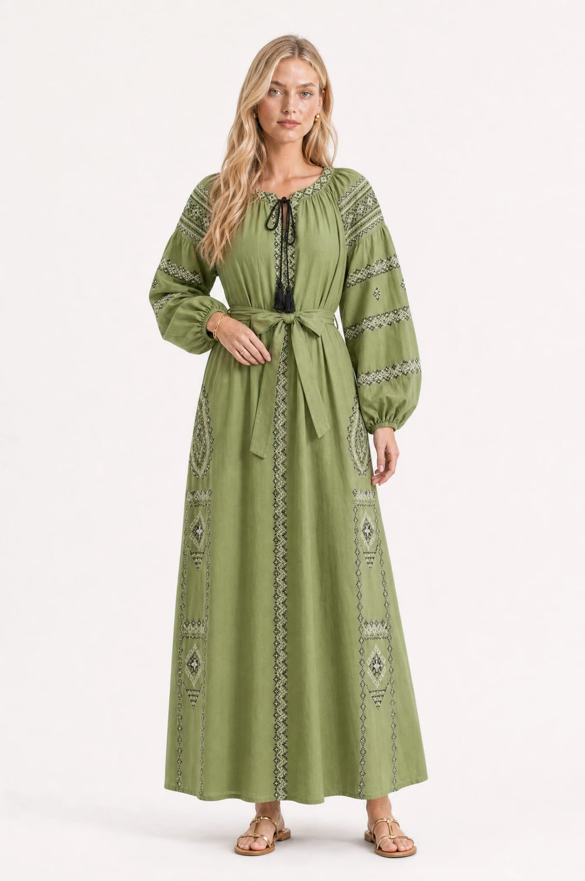 Robe vintage brodée verte Romane portée de face par Sophie cheveux détachés, décolleté rond fermé par un lacet noué, broderie ethnique bicolore noir et blanc sur les manches bouffantes et la jupe, ceinture nouée à la taille, style folk chic