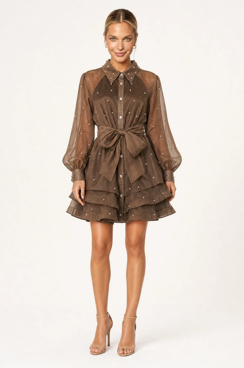Robe vintage perlée kaki Colette portée de face par Aude chignon sleek, col chemisier structuré, boutons perlés et strass sur le buste, manches bouffantes en organza semi-transparent, ceinture nouée à la taille, jupe courte à volants superposés