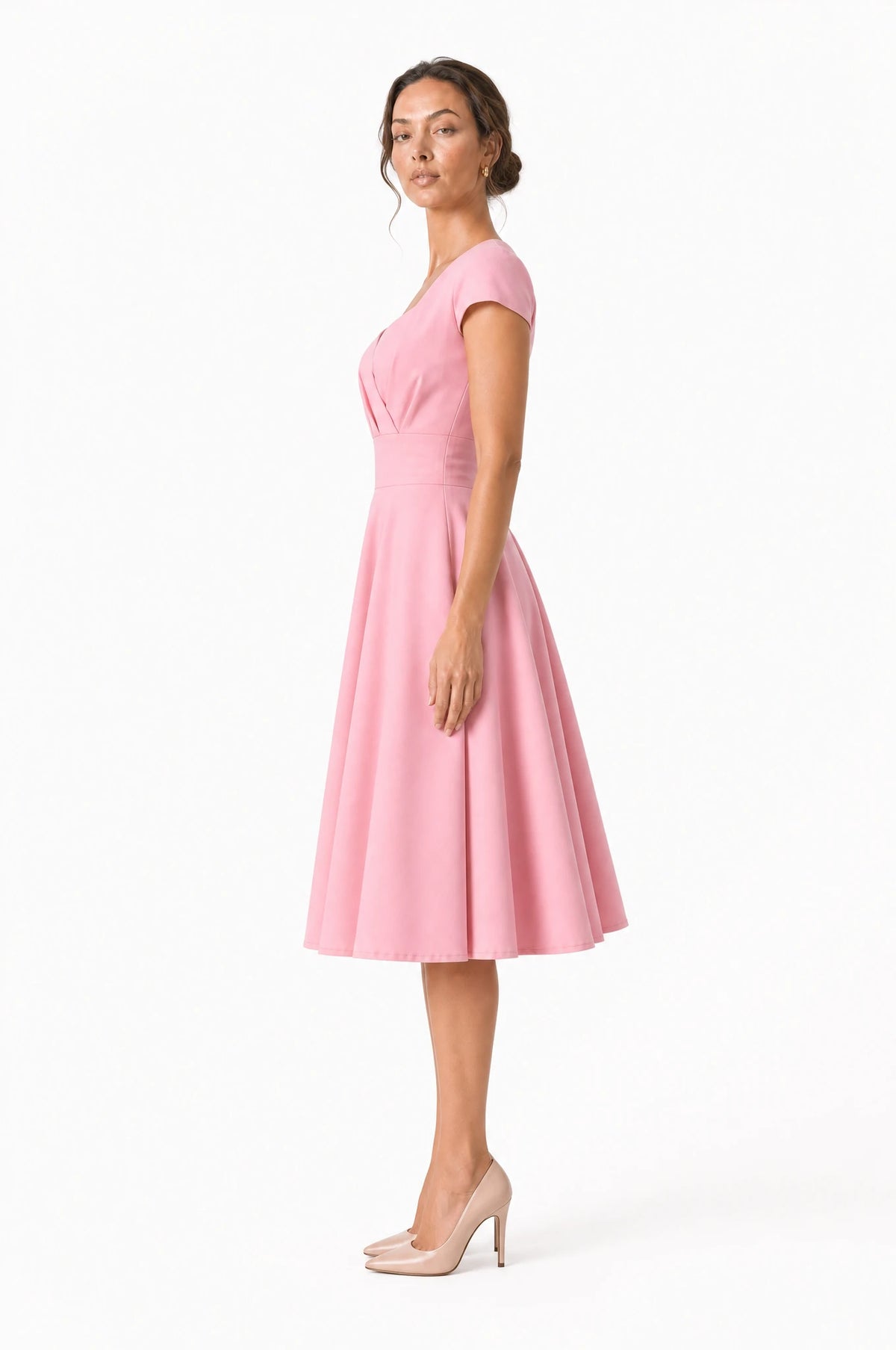 Robe vintage rose Odette vue de profil portée par Nath, silhouette pin-up, large ceinture à la taille, jupe ample en corolle jusqu'au genou