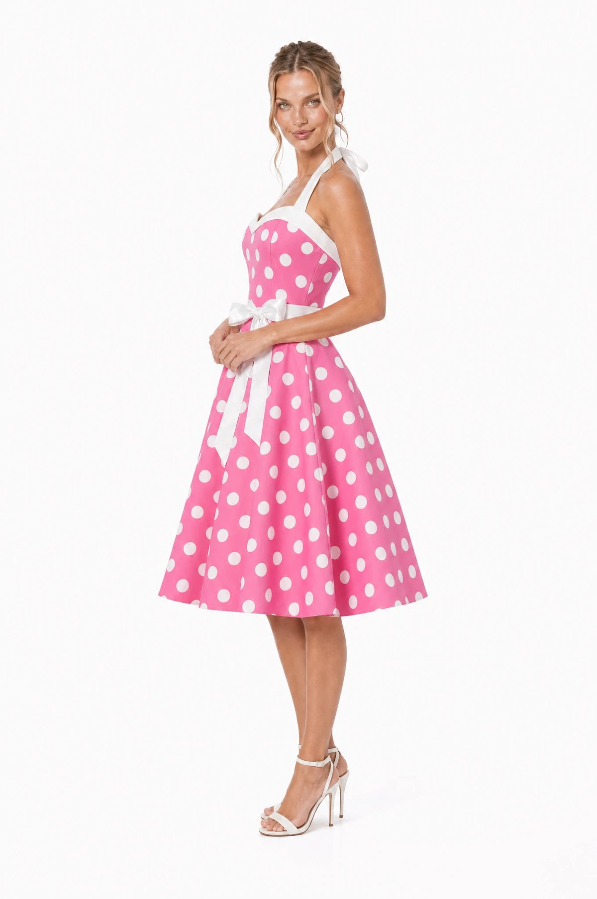 Robe Année 50 rose à pois Simone vue de profil portée par Aude, silhouette pin-up, large ceinture blanche à la taille, jupe ample en corolle jusqu'au genou