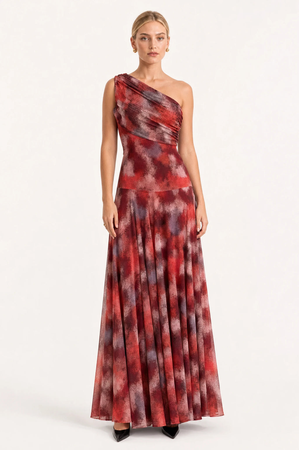 Robe vintage longue une épaule Isaline portée de face par Sophie cheveux blonds tirés en chignon, drapé asymétrique dégageant une épaule, imprimé marbré rouge bordeaux et gris fumé, jupe maxi fluide jusqu'au sol
