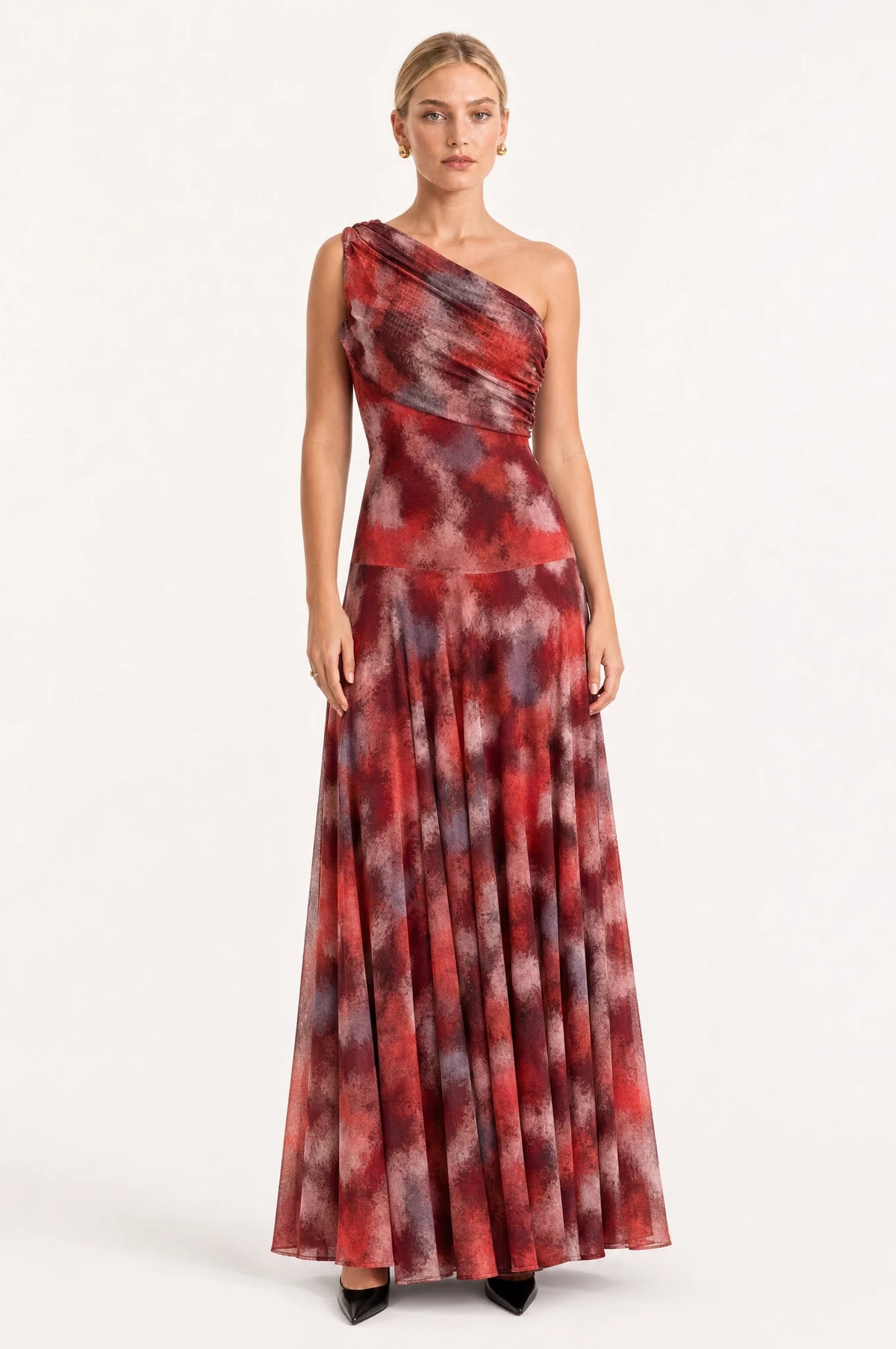 Robe vintage longue une épaule Isaline portée de face par Sophie cheveux blonds tirés en chignon, drapé asymétrique dégageant une épaule, imprimé marbré rouge bordeaux et gris fumé, jupe maxi fluide jusqu'au sol