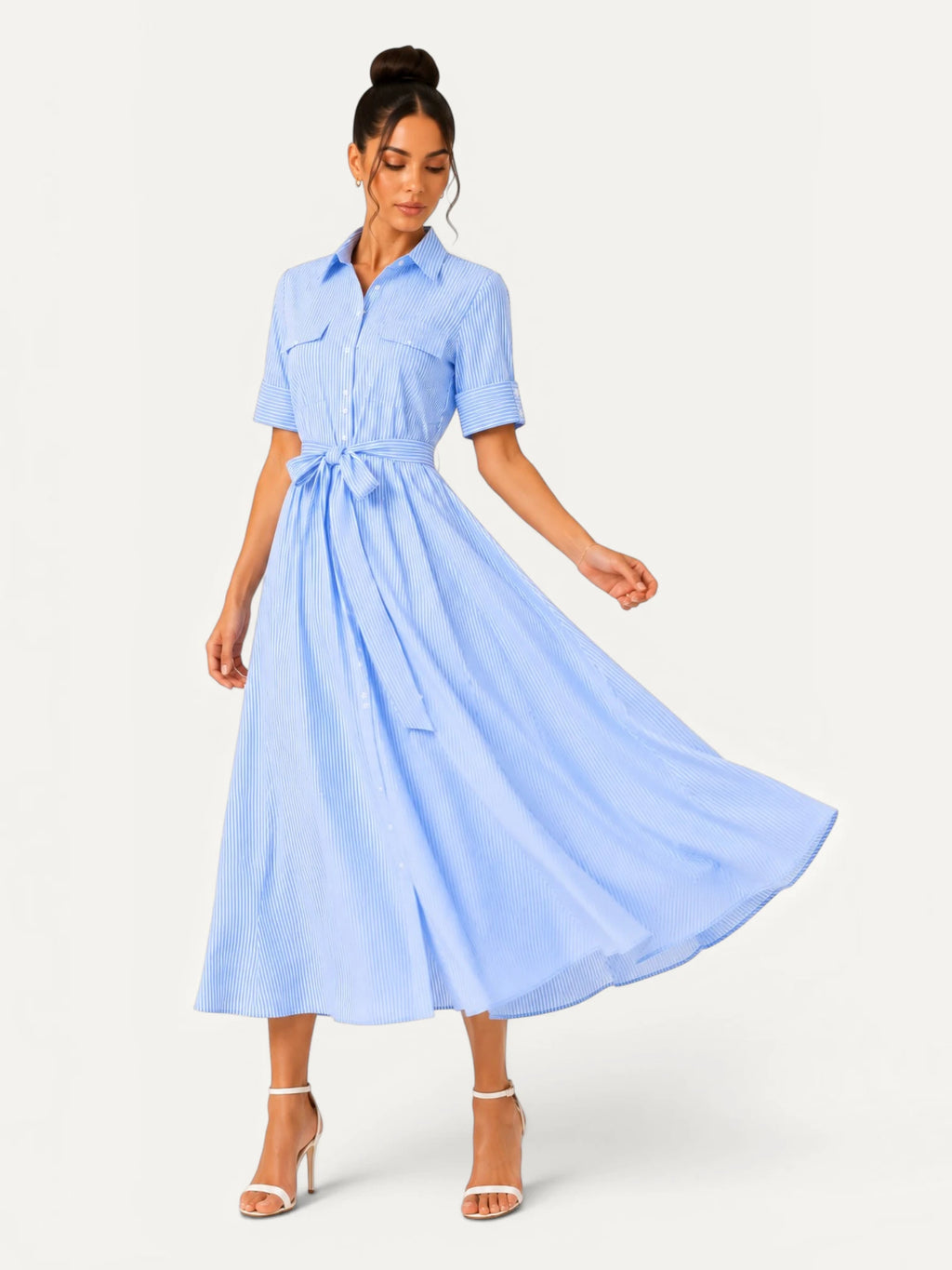 Robe chemise midi bleu ciel à rayures fines en mouvement, mettant en valeur la fluidité du tissu, la coupe évasée et l’élégance naturelle de la silhouette.
