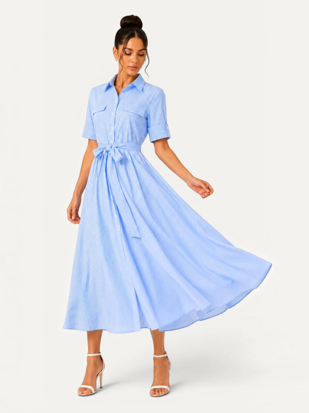 Robe chemise midi bleu ciel à rayures fines en mouvement, mettant en valeur la fluidité du tissu, la coupe évasée et l’élégance naturelle de la silhouette.