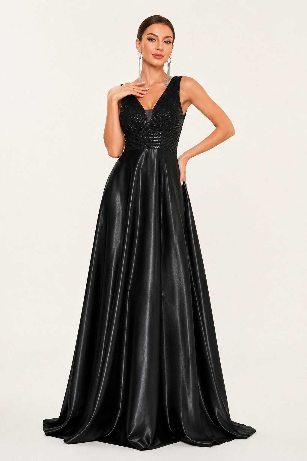 Robe de soirée longue noire satinée avec décolleté en V profond, bustier scintillant à sequins et jupe ample fluide pour une silhouette élégante et sophistiquée.
