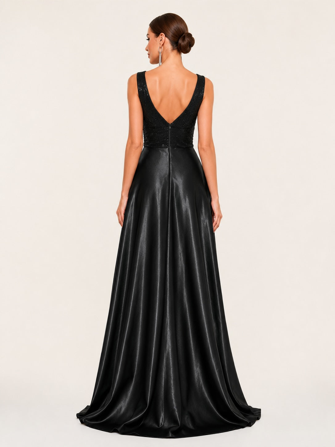 Dos en V raffiné d’une robe longue noire de cérémonie, associant corsage pailleté et jupe satinée majestueuse au tombé impeccable.