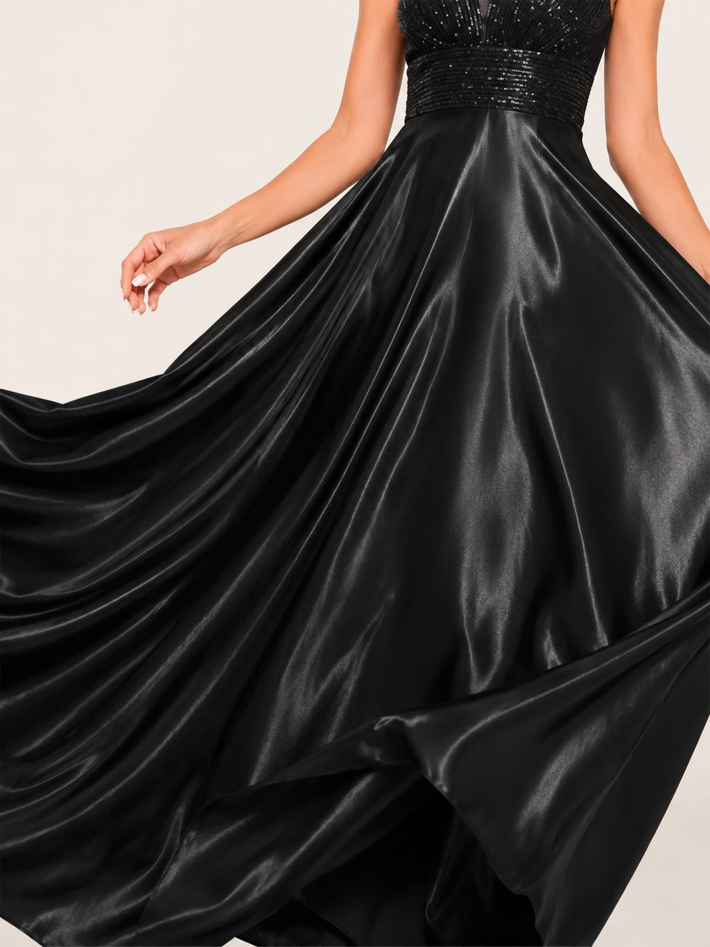 Détail de la jupe satinée noire aux reflets lumineux, révélant l’ampleur du volume et la qualité premium du tissu.