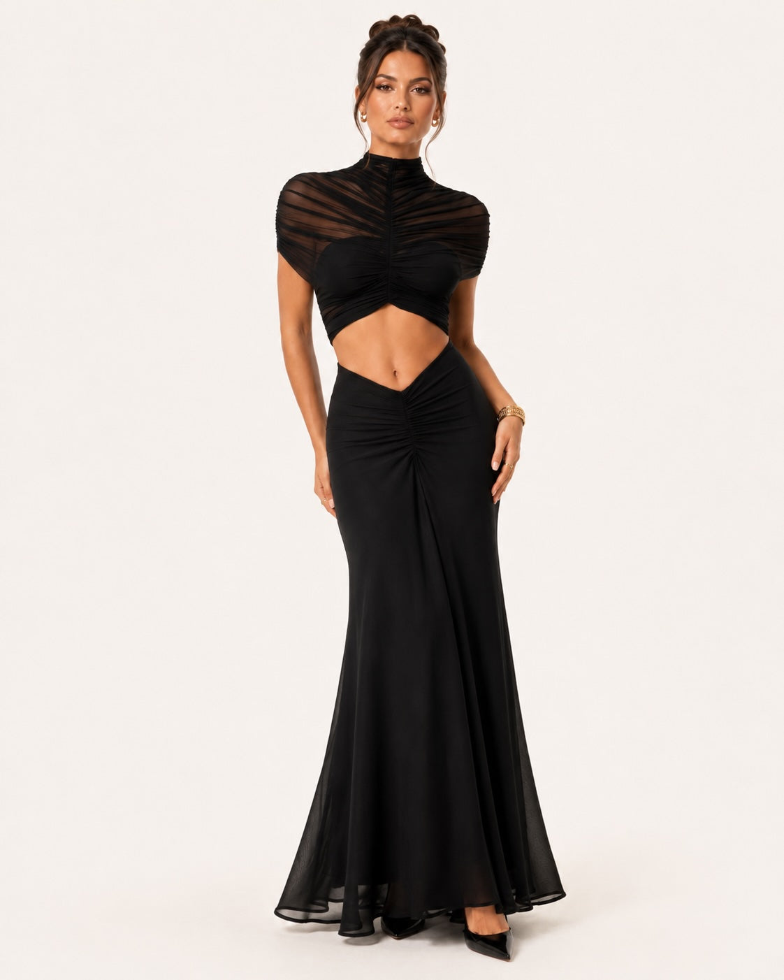 Robe longue noire de cérémonie avec haut en tulle transparent plissé, détails froncés et coupe sirène moderne, idéale pour une soirée cocktail ou un gala.