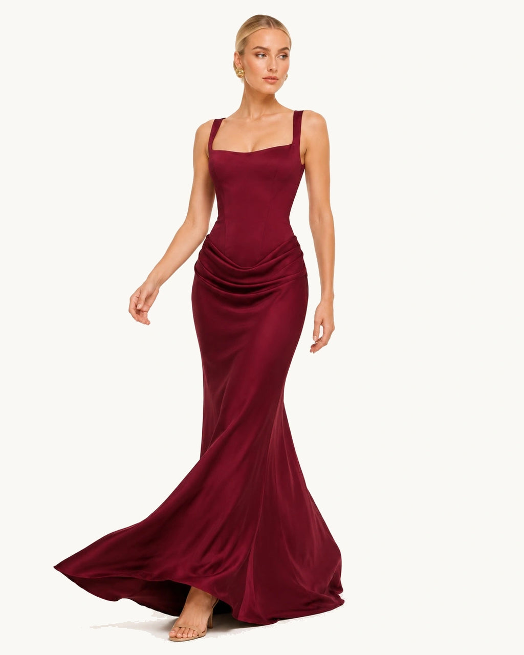 Le drapée sur les hanches épouse bien la silhouette. La robe bordeaux longue cintrée au niveau du buste et évasée sur la longueur révèle la fluidité et la légèreté du tissu. Allure chic et élégante assurée.