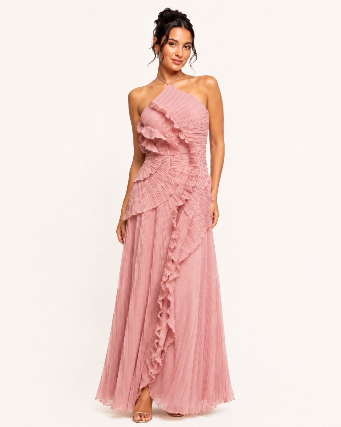 Robe longue plissée rose poudré avec encolure asymétrique et volants en spirale sur le buste, créant une silhouette remarquable pour les grandes occasions. Image
