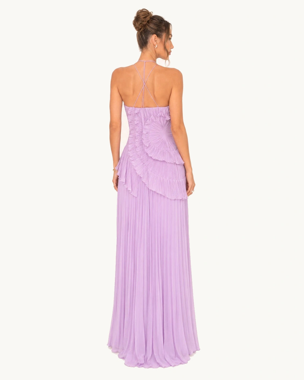 Vue dos d'une robe longue lilas plissée avec fines bretelles croisées et jupe fluide tombant jusqu'au sol.