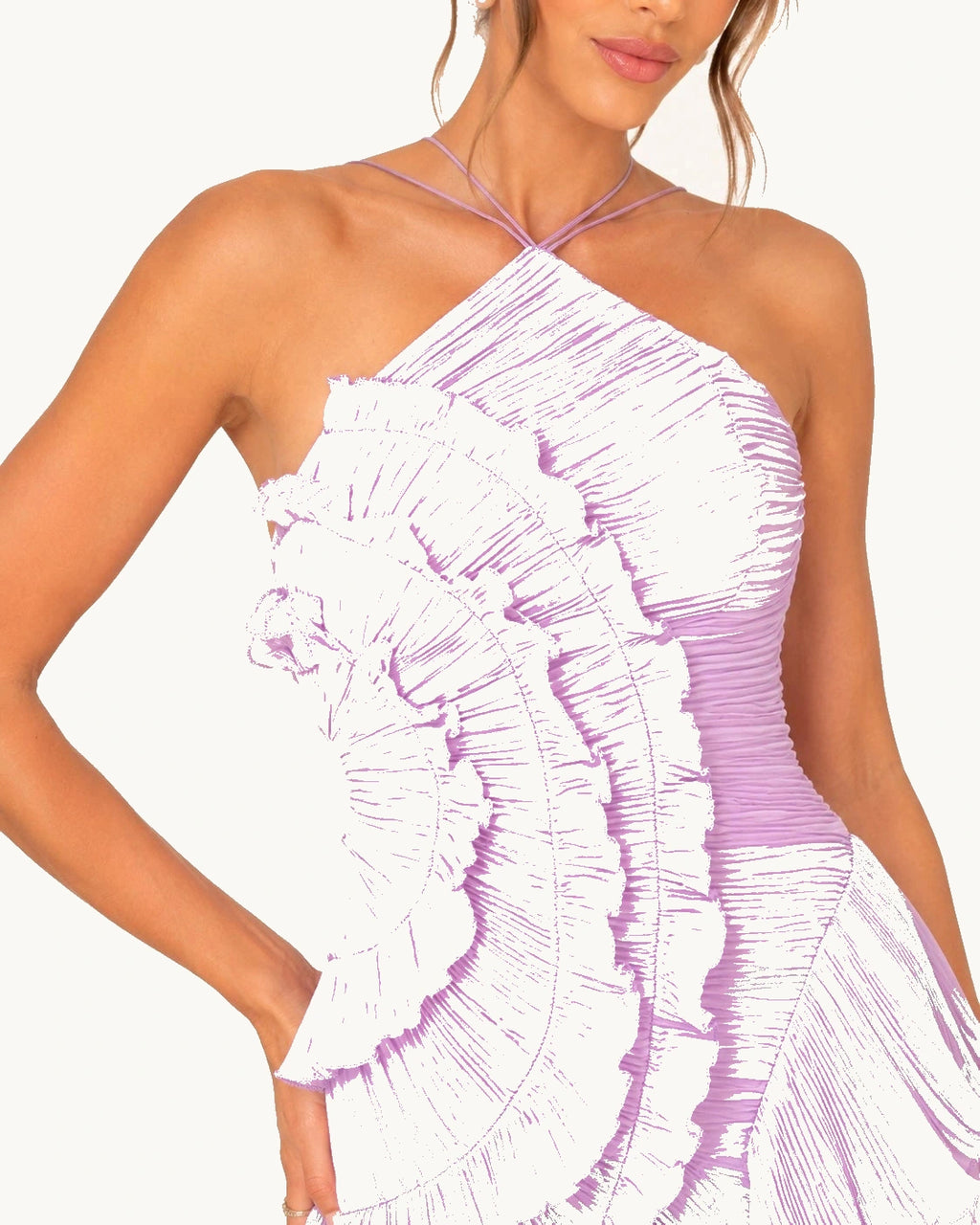 Gros plan sur le buste d'une robe de cérémonie lilas à encolure asymétrique et volants plissés travaillés en relief.