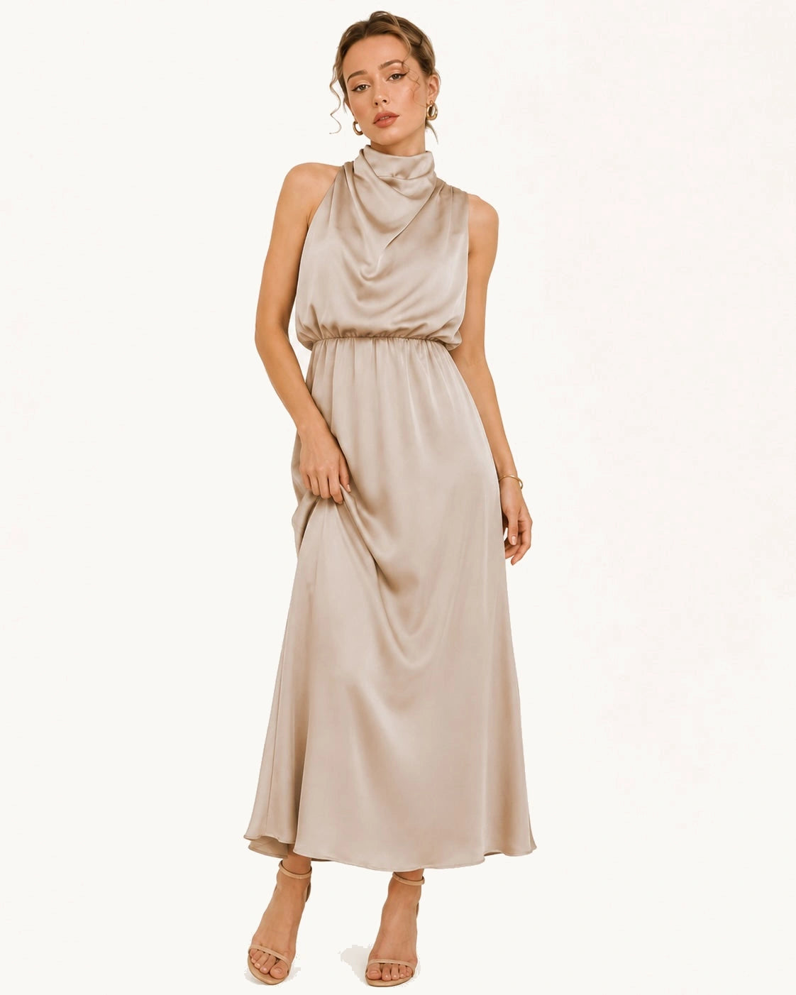 Robe longue beige satinée portée par une femme blonde posant de face. Cette élégante robe au col légèrement montant drapé et son tombé fluide, vous accompagnera avec class et prestige pour vos évènements importants. Image