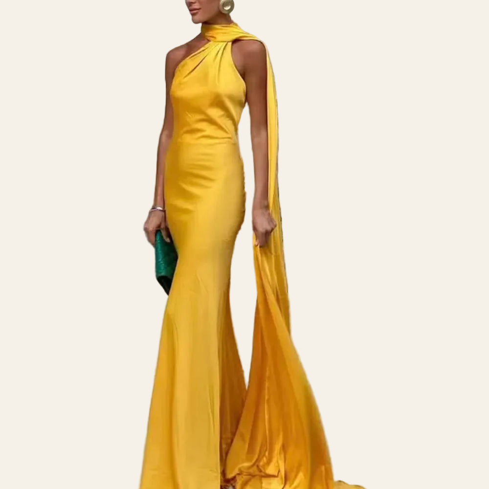Robe Longue Satinée Col Drapé Avec Traîne. Le mannequin porte une robe longue jusqu'au sol jaune doré. Elle tient la traine dans la main qui lui donne une allure élégante. Image