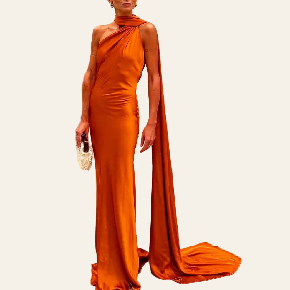 Robe Longue Satinée Col Drapé Avec Traîne. Le mannequin porte une robe longue jusqu'au sol orange. La traine accompagne sa silhouette lui apportant une allure élégante. Image
