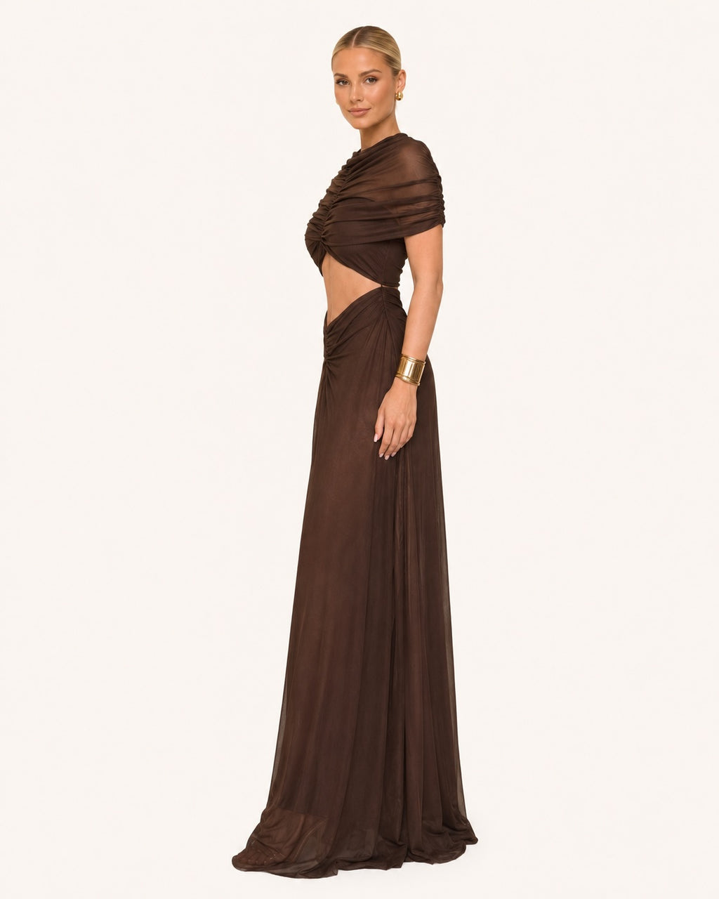 Robe longue marron chocolat élégante avec découpes à la taille, drapé transparent sur les épaules et jupe fluide maxi, idéale pour une cérémonie, un gala ou une soirée chic.