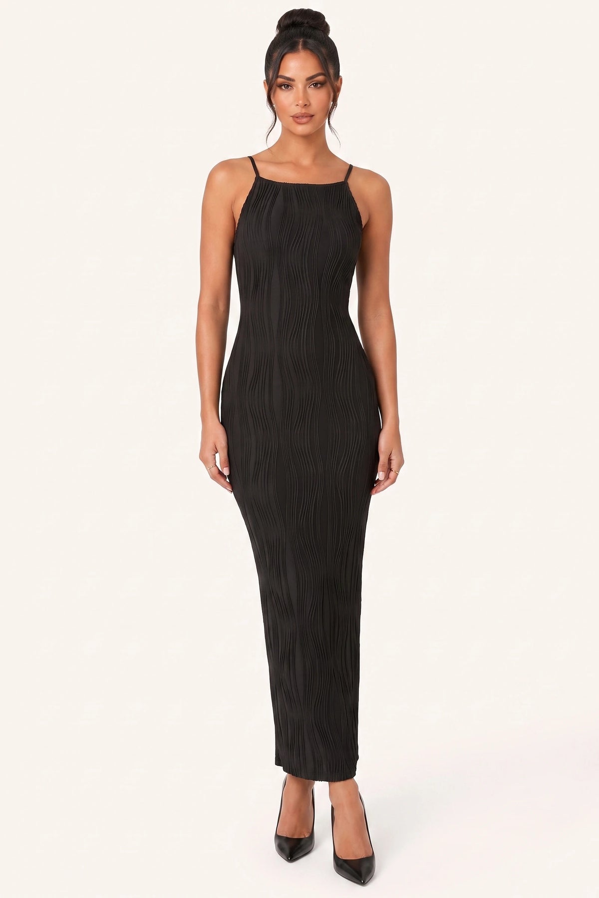 Robe moulante longue Maëlys noire portée de face par le mannequin Diane Camille sur fond neutre clair, photo visible galerie client, fines bretelles, texture plissée ondulée et ligne ajustée